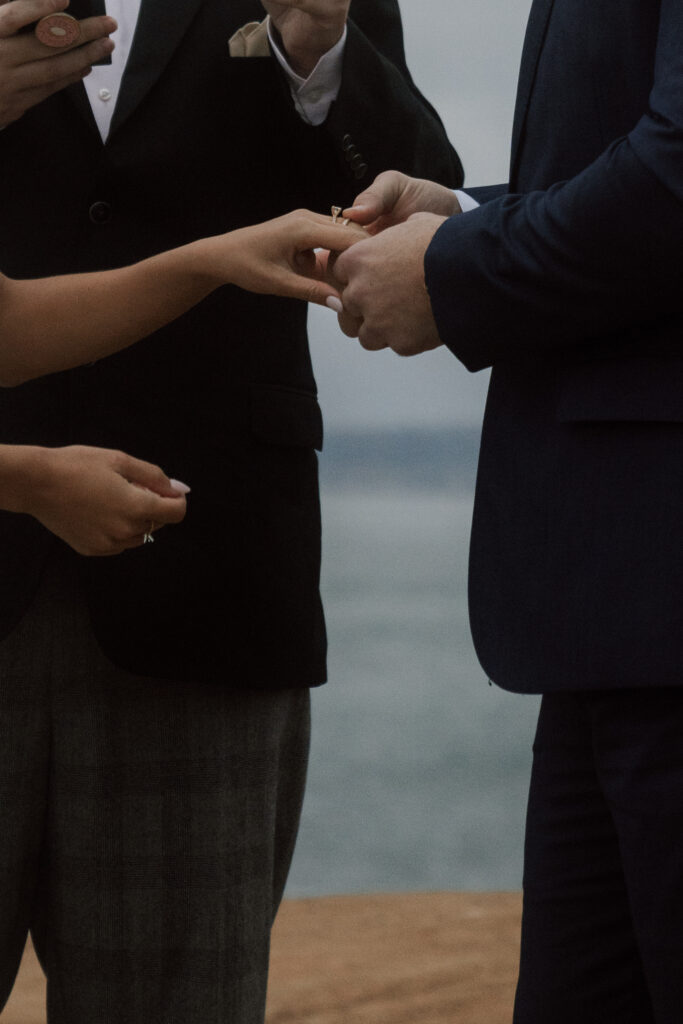 bride and groom exchanging rings at california oceanside wedding