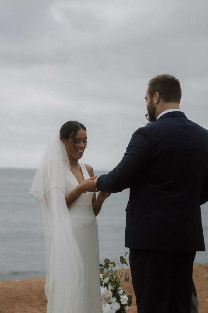 bride and groom exchanging rings at california oceanside wedding