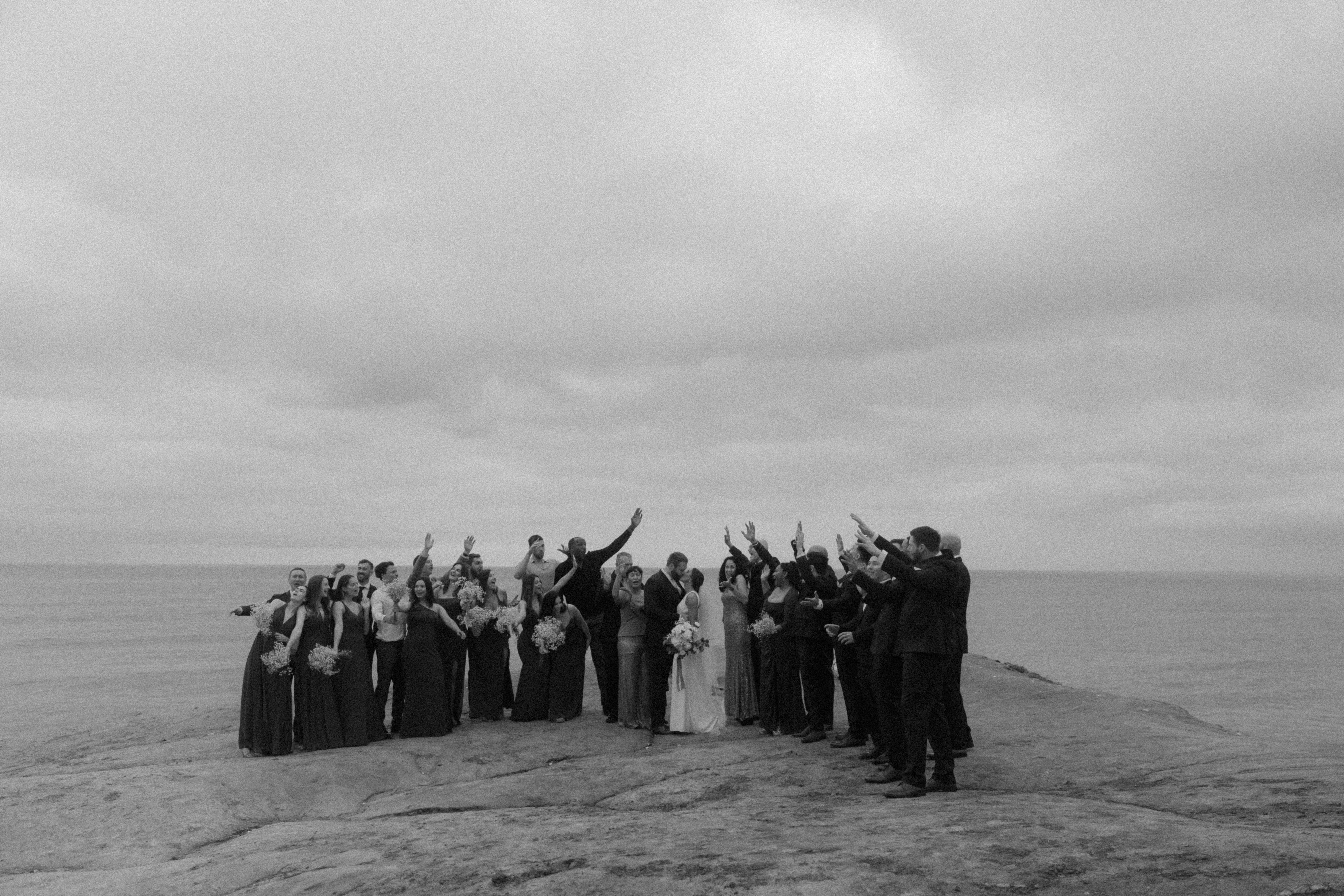 family celebrating bride and groom at wedding ceremony at sunset cliffs