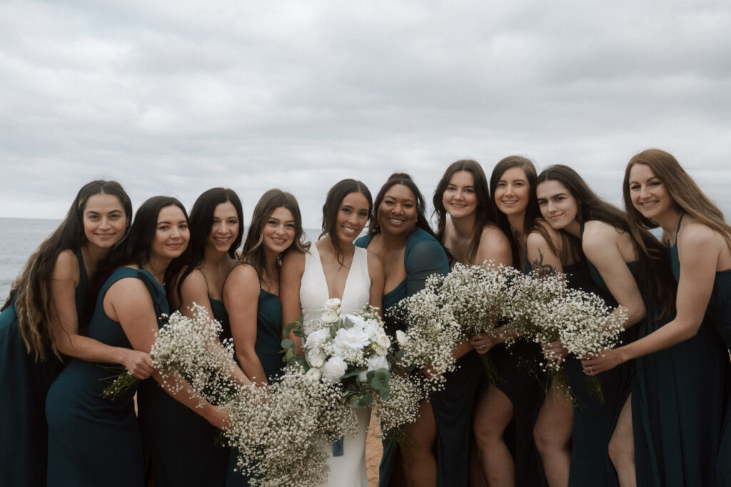bridesmaids smiling at sunset cliffs in san diego california