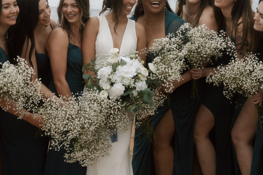 bridesmaids in green dresses holding white flowers