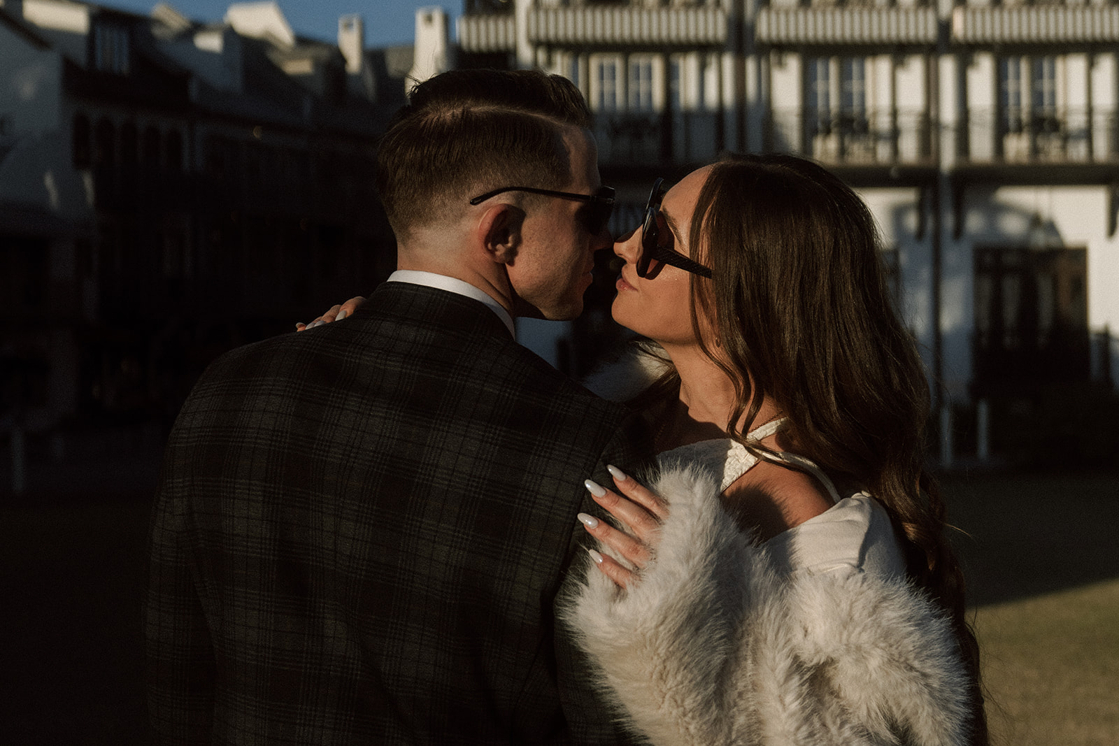 Rosemary Beach engagement photo with mob wife fashion vibes against European-inspired architecture and palm greenery