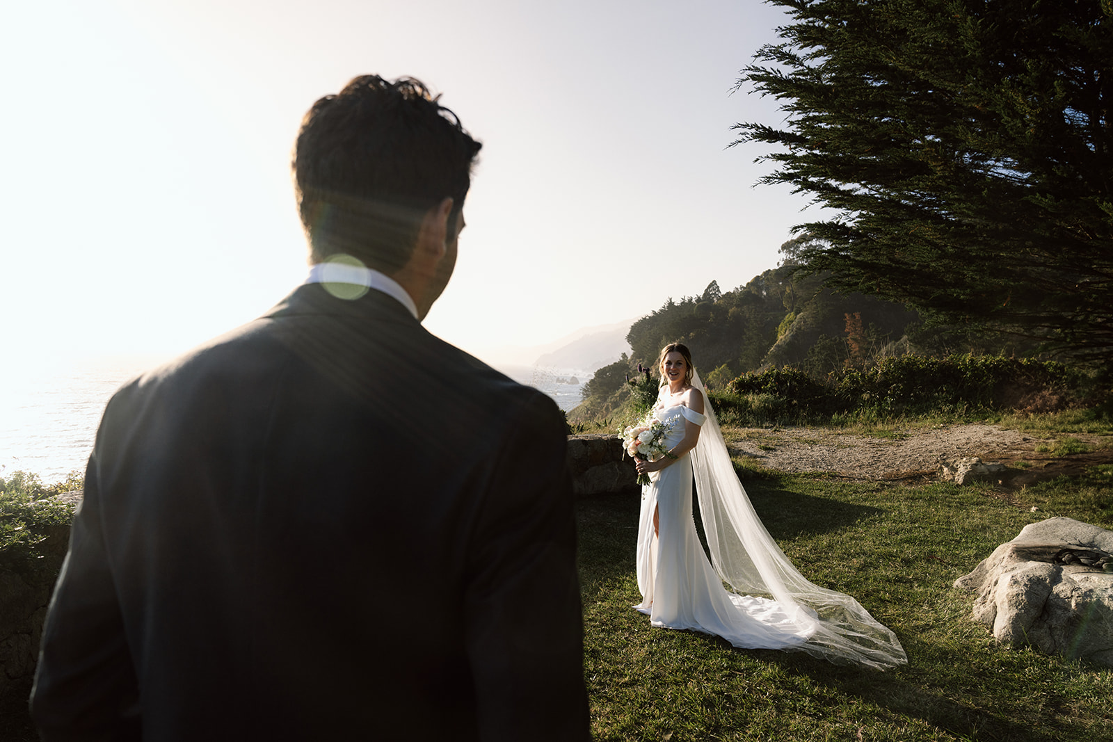 Newlyweds sharing a quiet moment at sunset on the cliffs of Big Sur