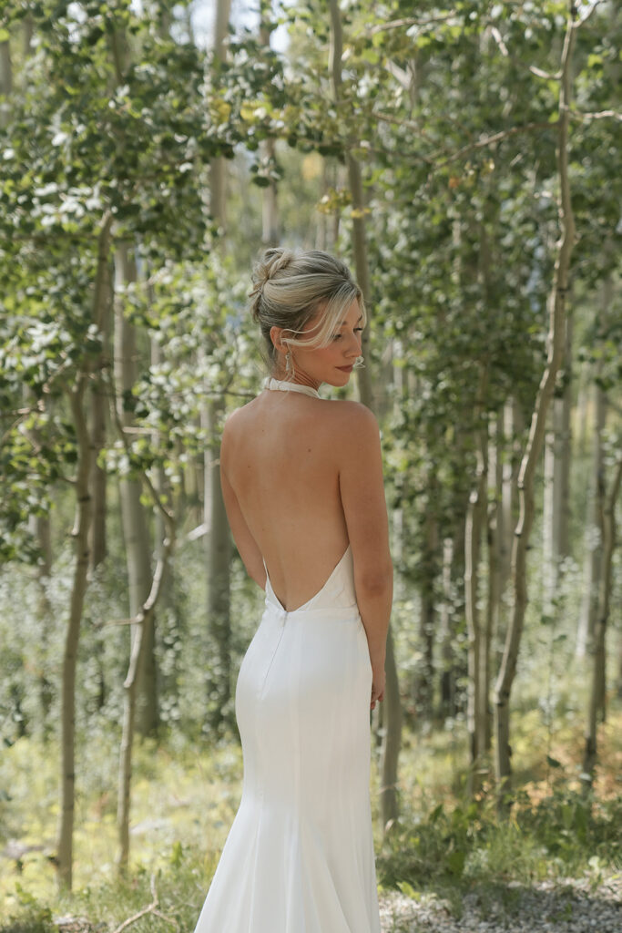 bride posing elegantly in front of aspen grove
