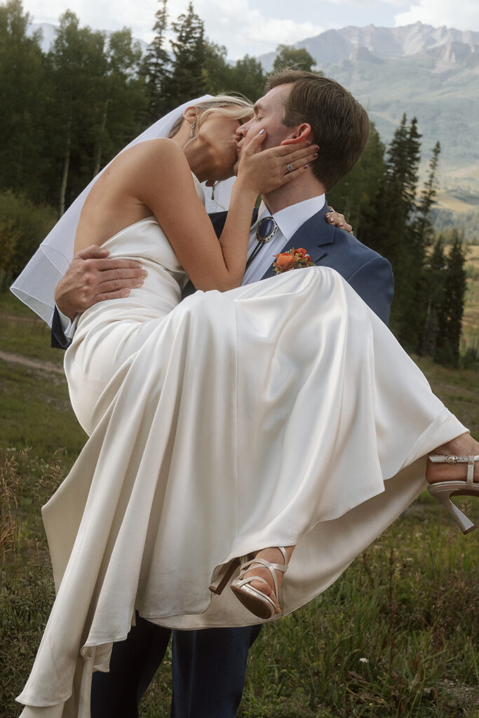 bride and groom kissing with san juan mountain backdrop